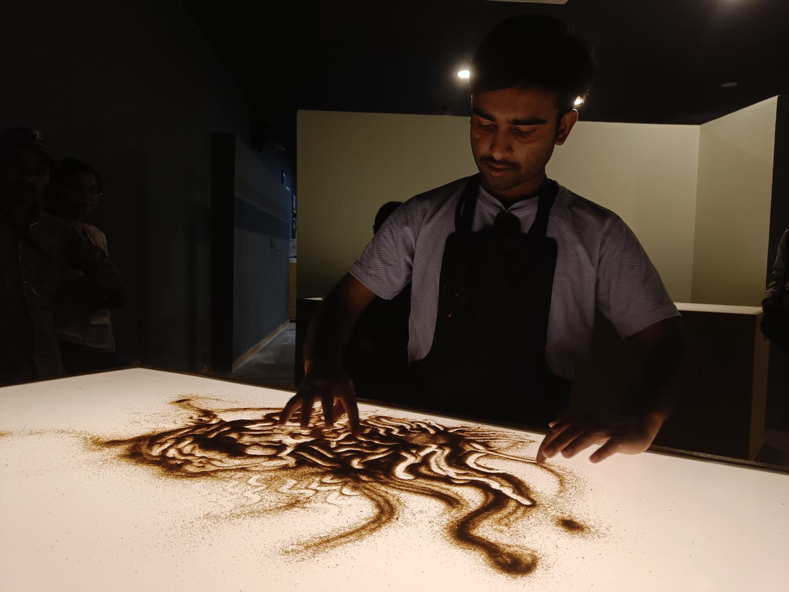 Person creating sand art in The Sand Room